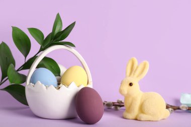 Paskalya yumurtası, tavşan ve mor arkaplan dallı sepet.