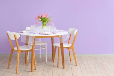 Yemek masası ve lale çiçekleri odadaki renk duvarının yanında Uluslararası Kadınlar Günü kutlamalarında servis edildi.