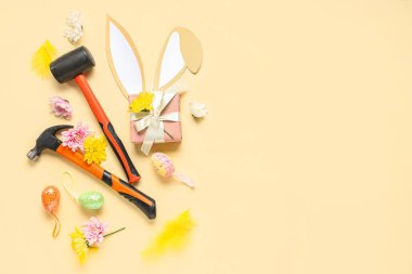 Renk arkaplanındaki yapıcı araçları, hediye kutusu ve Paskalya dekoru ile kompozisyon