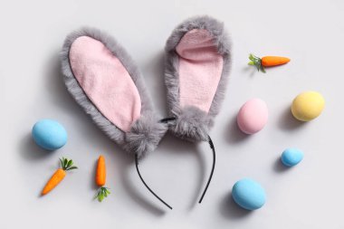 Beyaz arka planda havuçlu tavşan kulakları ve Paskalya yumurtaları.