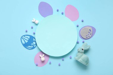 Paskalya tavşanı, kağıt yumurta ve mavi arka planda boş kart. Üst görünüm
