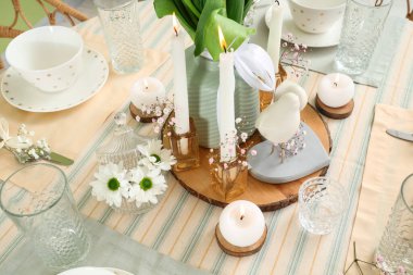 Uluslararası Kadınlar Günü kutlamaları için yanan mumlar ve çiçeklerle dolu güzel bir masa.