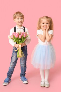Pembe arka planda bir buket güzel lalesi olan şirin küçük çocuklar. Uluslararası Kadınlar Günü