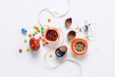 Beyaz arka planda şekerli ve kurdeleli Paskalya yumurtaları