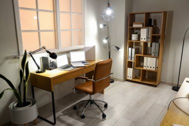 İş yeri, dizüstü bilgisayarlar ve parlayan lambalar olan modern ofis.