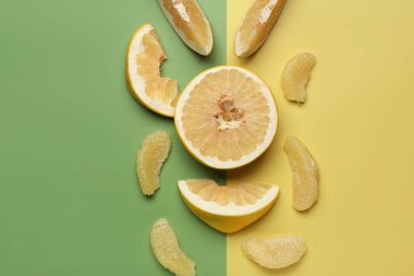 Renkli arka planda dilimlerle tatlı pomelo kes