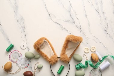 Paskalya yumurtası ve beyaz mermer arka planda terzi malzemesi olan tavşan kulaklı.