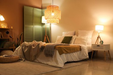 Yatak odasının içinde ekose kumaşlar ve geceleri parlayan lambalar.