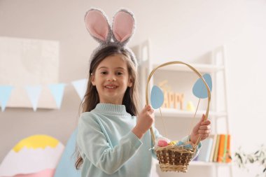 Evinde Paskalya sepeti olan sevimli küçük bir kız.