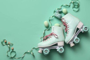 Yeşil arka planda Paskalya yumurtası ve oyuncak tavşanı olan klasik patenler.