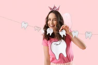 Pembe arka planda kağıt dişli diş perisi.