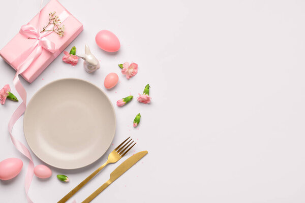 Прекрасная сервировка пасхального стола с розовыми подарками, цветами и яйцами на белом фоне