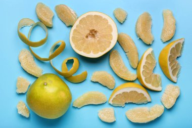 Lezzetli bir bütün ve mavi arka planda dilimlenmiş pomelo meyveleri