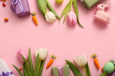 Hediye kutularıyla lale çiçekleri ve pembe arka planda Paskalya tavşanı.