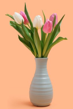 Turuncu arka planda güzel laleleri olan vazo. Uluslararası Kadınlar Günü