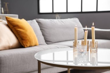 Modern oturma odasındaki masada mum yakmak, yakın çekim.