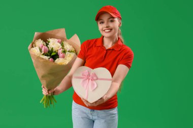 Çiçek buketi ve yeşil arka planda hediye kutusu olan kadın kurye.