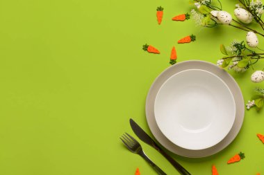 Yeşil arkaplandaki çiçeklerle servis edilen basit şirin Paskalya sofrası