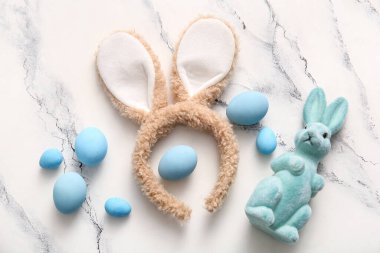 Paskalya yumurtaları ve beyaz mermer arka planda tavşan kulaklı oyuncak