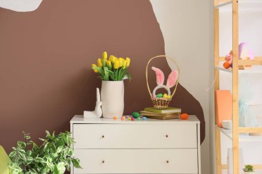 Laleli vazo, Paskalya yumurtası ve oturma odasında klozet üzerine kitaplar.