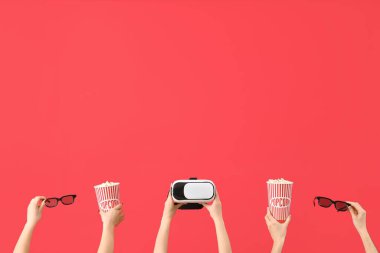 Patlamış mısır, VR kulaklık ve kırmızı arka planda 3D gözlük tutan eller.