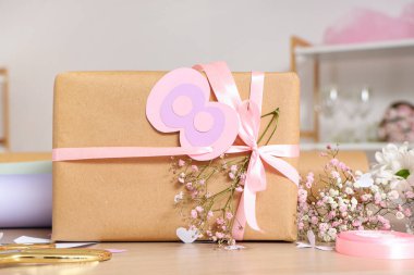 Tahta masadaki Uluslararası Kadınlar Günü için çingene çiçekli güzel bir hediye kutusu.