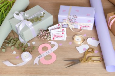 Güzel hediye kutuları, ambalaj malzemeleri ve tahta arka planda tebrik kartları. Uluslararası Kadınlar Günü