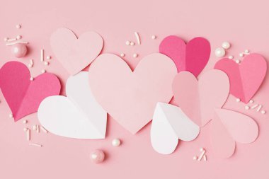 Pembe arka planda dekorlu kağıt kalpler. Sevgililer Günü kutlaması