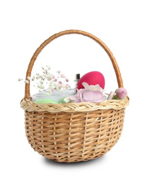 Beyaz arka planda parfümlü hasır sepet, paskalya yumurtaları ve çiçekler.
