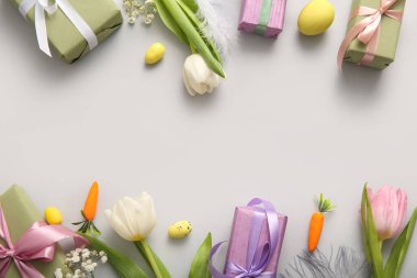 Çiçekli Paskalya yumurtaları ve gri arka planda hediye kutuları.