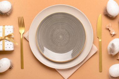 Bej arka planda yumurtalar ve hediyelerle süslü Paskalya sofrası.