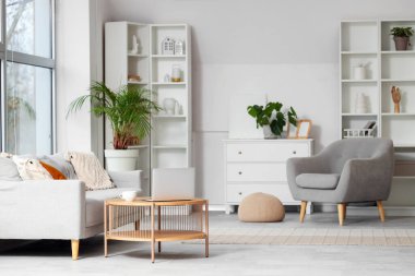 Gri koltuğu, kanepesi ve masası olan modern oturma odası.