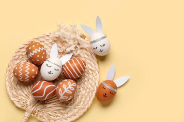 Bej arkaplanda yaratıcı Paskalya yumurtaları olan kompozisyon
