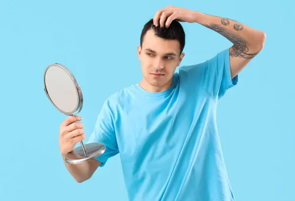 Jovem Com Problema Perda Cabelo Espelho Fundo Azul — Fotografia de Stock