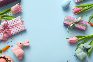 Paskalya yumurtaları, lale çiçekleri hediye kutuları ve mavi arka planda tavşanlar.
