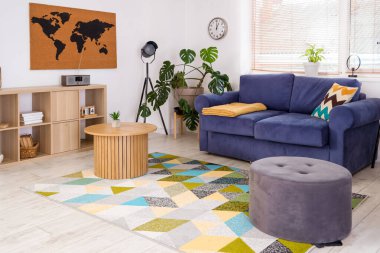 Şık oturma odasının içinde kanepe, masa ve puf