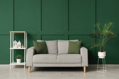 Rahat kanepesi, çiçekleri ve rafları olan şık bir oturma odası.