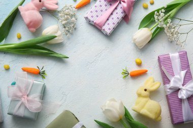 Hediye kutuları ve mavi grunge arka planda tavşanlarla yapılmış paskalya yumurtalarından yapılmış çerçeve.