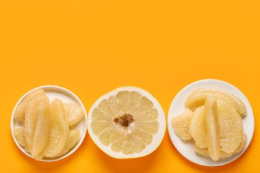 Turuncu arka planda parçaları olan lezzetli aromalı meyve ve tabaklar.