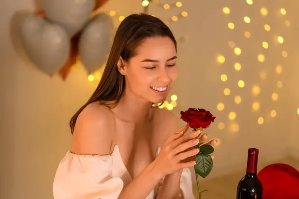 Happy young woman with rose and ring at home. Valentine\'s Day celebration