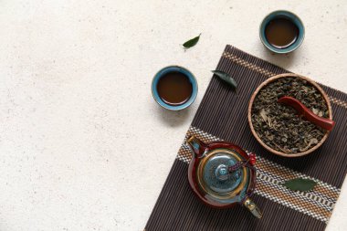 Estetik seramik çaydanlık ve beyaz zemin üzerinde kuru puer çay ile mat