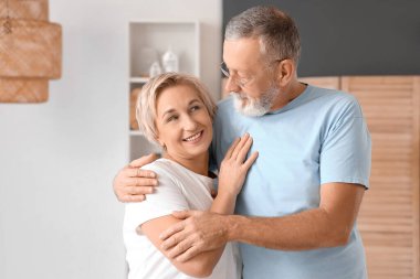 Evde kucaklaşan olgun bir çift.