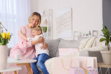 Küçük çocuk evde annesine sarılıyor. Uluslararası Kadınlar Günü