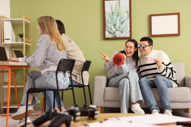 Osuruk yastıklı genç meslektaşlar ofiste eşek şakası yapmayı planlıyor. 1 Nisan Kutlaması