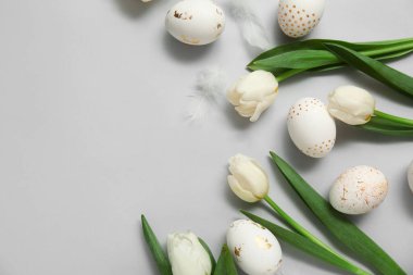 Paskalya yumurtalı laleler ve beyaz arka planda tüyler
