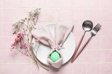 Paskalya için çok güzel bir sofra. Arka planda pembe çiçekler ve yumurta var.