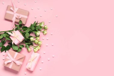 Pembe arka planda güzel güller ve hediye kutuları