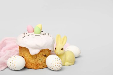 Beyaz arka planda yumurta ve tavşan heykelciği olan Paskalya pastası.