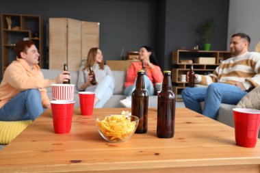 Patates cipsi ve bira. Partide masada, yakın plan.