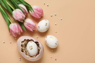 Paskalya yumurtaları ve bej arka planda laleler.
